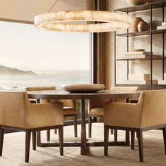 a dining room table with chairs and a large window overlooking the ocean in front of it