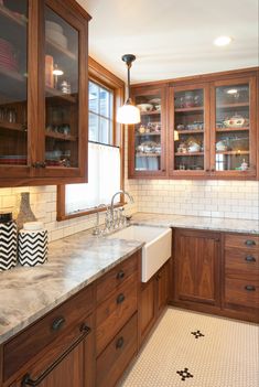 a kitchen with wooden cabinets and marble counter tops