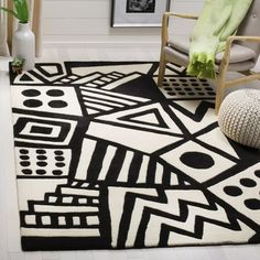 a black and white area rug with geometric designs on it in a living room next to a chair