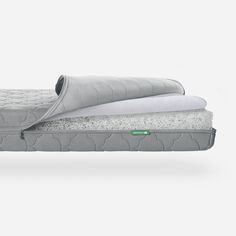 two mattresses sitting side by side on top of each other, one with a pillow and the other without