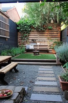 an outdoor area with wooden benches, plants and graveled path leading to the back yard