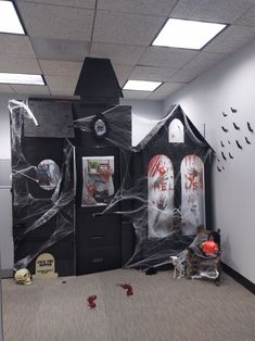 an office decorated for halloween with black and white decorations on the door, walls and floor