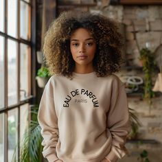 Indulge in the luxurious warmth and style of this cute beige "Eau de Parfum, Paris" Sweater. Featuring delicate French text detailing for a touch of Parisian charm, this sweater is the perfect gift for your girlfriend or any fashionable woman in your life. It  provides both comfort and elegance, making it a versatile addition to any wardrobe. Stay cozy and chic with this must-have sweater that effortlessly combines fashion and sophistication. * 50% cotton, 50% polyester * Pre-shrunk * Classic fi Paris Sweater, Text Gift, Ladies Sweater, Womens Hoodies, Gifts For Your Girlfriend, Gift For Girlfriend, Summer Wardrobe, Summer Looks, Fashion Item