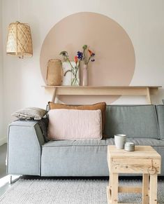 a living room with a couch, table and vases on the wall above it