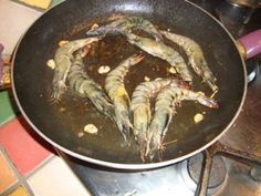 shrimp being cooked in a frying pan on the stove