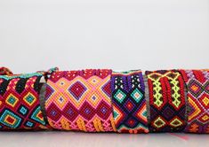 a roll of multicolored beaded bracelets on a white surface with reflection