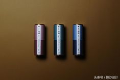 three batteries sitting side by side on a brown surface