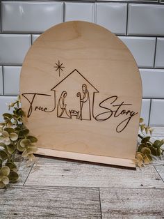 a wooden sign with the word jesus story written on it and an image of a house