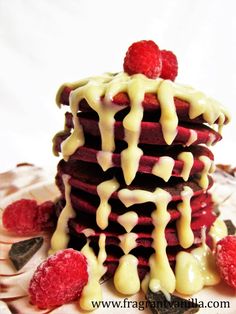 a stack of raspberry pancakes covered in white icing and drizzled with cream