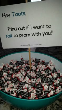 a bowl full of candy and a sign that says they toots find out if i want to roll to prom with you