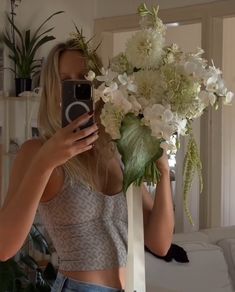 a woman taking a selfie with flowers in front of her