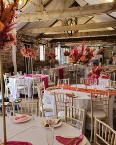 tables and chairs are set up with white linens, pink napkins, and flowers