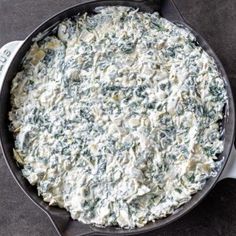 spinach dip in a cast iron skillet ready to be served on the table