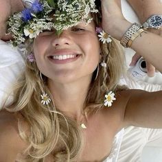 a woman laying on top of a bed with flowers in her hair and two men around her