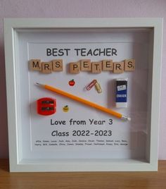 a white frame with some scrabbles on it and a pencil in the middle