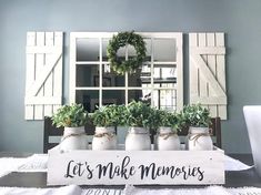 there is a sign that says let's make memories with potted plants on the table