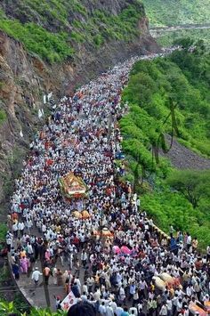 a large group of people walking up the side of a mountain