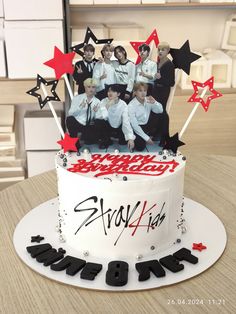 a birthday cake with an image of the band bts on top and stars around it