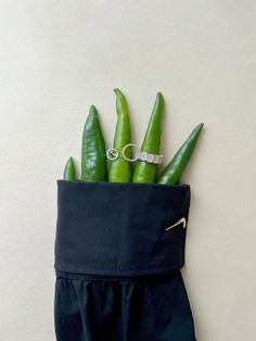 some green beans in a blue bag on a white wall with a pair of scissors