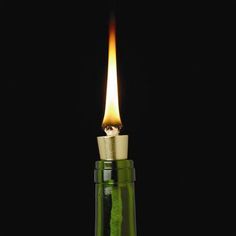 a small green bottle with a candle in it