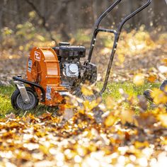 an orange lawn mower sitting in the grass