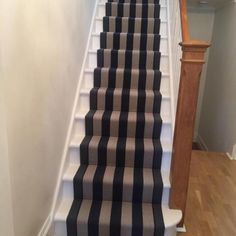 the stairs are lined with black and white striped carpet