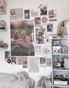 a bedroom with many pictures on the wall and shelves full of books, magazines, and other things