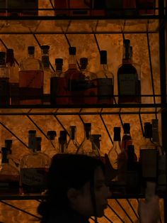 a woman standing in front of shelves filled with bottles