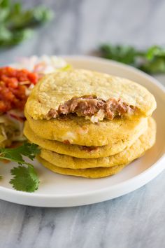 mexican food on a white plate with garnishes