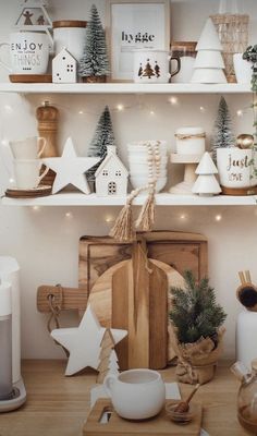 a kitchen with christmas decorations on the shelves and coffee pot, mugs, teapot