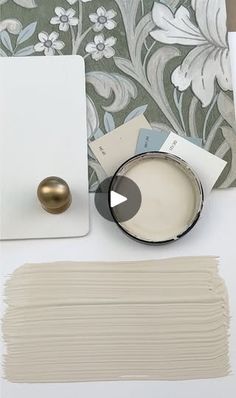 the paint is being used to create a floral wallpaper design with white and gold accents