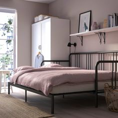 a bedroom with pink walls and white furniture