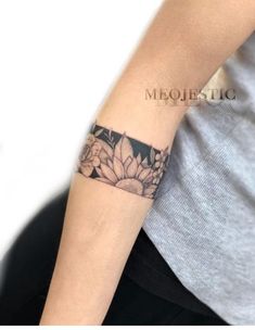 a woman's arm with a flower tattoo on the left side of her arm