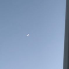 the moon is visible in the clear blue sky