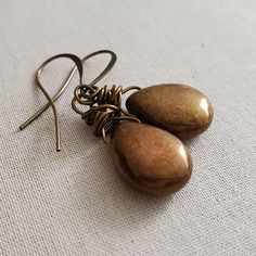 "Bronze Glass Teardrop Earrings, Rustic Bronze Brown Earrings, Rustic Bronze Earrings, Brass, Boho, Wire Wrapped You have to admire the simplicity of these glittery bronze glass drops. I took these these gorgeous bronze glass teardrops and minimally wired them in antiqued bronze copper core wire. I hung from hypoallergenic antiqued brass earwires. From the top of the leverback wires earrings fall 1.5 inches or the artisan french hooks, 1.75 inches. Choose your preferred earwire at checkout. Bead Bronze Metal Dangle Teardrop Earrings, Bronze Metal Teardrop Dangle Earrings, Bronze Nickel-free Drop Earrings, Adjustable Teardrop Bronze Earrings, Adjustable Bronze Drop Earrings, Hypoallergenic Bronze Metal Earrings, Bronze Metal Teardrop Earrings, Nickel-free Bronze Teardrop Earrings, Bronze Metal Teardrop Earrings For Gift