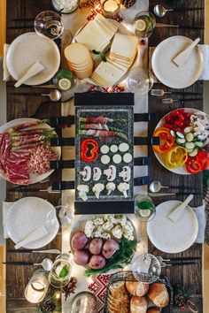 an overhead view of a table with food on it and candles in the middle,