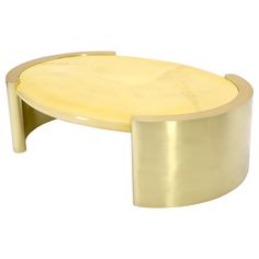 an oval coffee table with a gold finish on the top and bottom, sitting against a white background