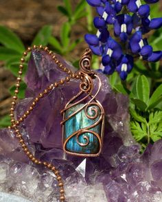 "This pendant features flashy rectangular labradorite. The gemstone is blue with hints of green and dark vertical slashes. The crystal is wire wrapped in a simple but swirly design intended to securely capture the stone while not obscuring much of the stone's face. There are swirling wire details in the bail to create continuity of the design from top to bottom. The wire is pure copper that has been antiqued and hand polished.  This boho necklace comes with an 18\" antique copper chain and lobster clasp. You can upgrade to a pure copper ball chain for $5. If you prefer a different length, let me know and I will gladly customize your chain for you! It ships for free in the US in a gift box. If you are ordering this for another person, I will include a handwritten note with your message for Luxury Wire Wrapped Necklace For Gift, Luxury Metal Wire Wrapped Necklaces, Wire Wrapped Crystal Pendant, Swirly Designs, Wire Wrap Jewelry Designs, Copper Wire Jewelry, Wire Wrapping Crystals, Wire Wrapping Stones, Necklace Wedding