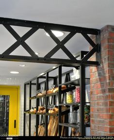 the shelves are filled with breads and pastries in front of a yellow door