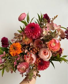 a person holding a bouquet of flowers in their hand