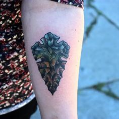 a woman's arm with a tattoo on it that looks like an acorn