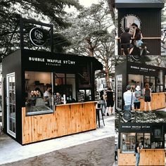 people are standing outside of the bubble waffle story booth at an outdoor event in winter