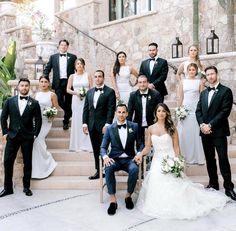 a large group of people in formal wear posing for a photo on some steps outside