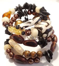 Attractive memory wire bracelet, an collage of African ethnic beads and brown glass. African Batik Bone is a large round bead of black and cream color, and there is tubular bead. Along with small African black beads and flat chips beads Several different shad of clear brown glass. A cream color elephant with trunk up Bronze and gold tone beads, one rhinestone bead All on one bracelet Brown Hand Wrapped Beaded Bangle, Brown Hand-wrapped Beaded Bangle, Brown Hand Wrapped Beaded Bangle Bracelet, Bohemian Brown Stretch Bracelet With Large Beads, Traditional Handmade Brown Stretch Bracelet, Unique Hand Wrapped Brown Beaded Bracelets, Unique Hand-strung Brown Beaded Bracelets, Unique Brown Beaded Bracelets, Brown Hand Wrapped Stretch Bracelet With Round Beads