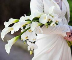 a woman in a white dress holding a bouquet of flowers