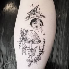 a woman's leg with tattoos on it and an image of the moon, mushrooms, stars and flowers