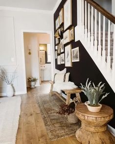 a living room filled with furniture and pictures on the wall next to a stair case