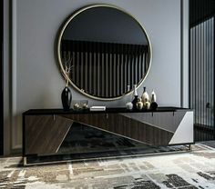 a black and white cabinet with a round mirror on it's wall above it