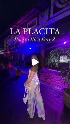 a woman standing in front of a building with the words la placita on it