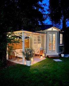 a small backyard with a gazebo and lights on it's sides at night